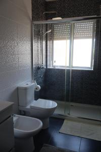 a bathroom with a toilet and a glass shower at Vivenda Atlantico in Vila Praia de Âncora +11 photos
