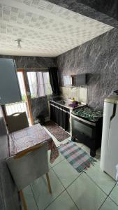 a small kitchen with a stove and a refrigerator at Kitnet aconchegante in Ouro Preto