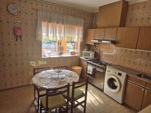 a kitchen with a table and chairs and a table and a window at Vivenda Atlantico in Vila Praia de Âncora