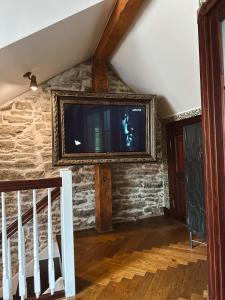 a living room with a tv on a stone wall at Karja Castle Apartments in Haapsalu