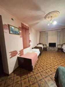 a hotel room with two beds and a flat screen tv at Matevosyans Guest House in Goris