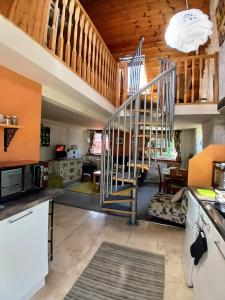 a kitchen with a spiral staircase in a house at Yr Hen Efail - Quirky Old Smithy cottage near forest walks, cycling & lakes in Garthbeibio +14 photos