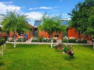 a house with a yard with flowers and trees at Cabanele Deltei in Dunavăţu de Jos
