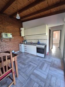 a kitchen with white cabinets and a wooden floor at Caranday in Cortaderas