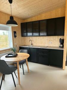 a kitchen with black cabinets and a table and chairs at New listing - Krosshóll Cottage, built in 2026 in Hella