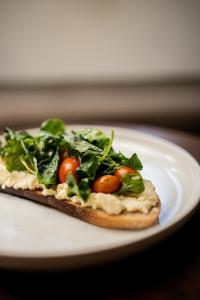 a small pizza on a white plate on a table at Suku Lifestyle Hotel & Villas in Selong Belanak +98 photos