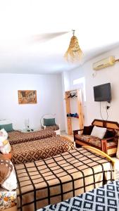a hotel room with two beds and a tv at Dar Aziz VIP in Sousse
