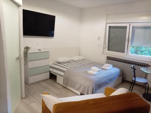 a small room with two beds and a tv at Bright & Sunny Studio in Sesvete