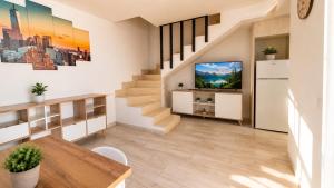 a living room with stairs and a television at Sunny Bungalow with Pool & Patio in Sonnenland By Canarias Prime Homes in Maspalomas