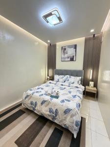a bedroom with a bed with a blue and white comforter at Eusel's Place Butuan in Butuan