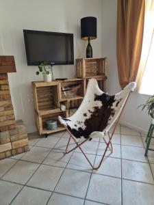 a living room with a chair and a television at M28 - Maison de campagne avec climatisation in Barby