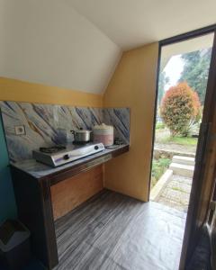 a kitchen with a counter with a stove in a room at Sabda Desa Cabin in Cinyiruan