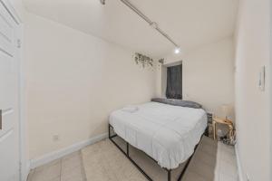 a bedroom with a bed in a white room at Chic One Bedroom Retreat in Downtown Manhattan in New York
