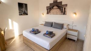 a bedroom with a white bed with two boxes on it at Sunny Bungalow with Pool & Patio in Sonnenland By Canarias Prime Homes in Maspalomas