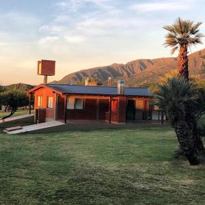 a house with a palm tree in a field at Caranday in Cortaderas