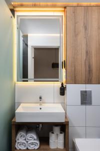 a bathroom with a sink and a mirror and towels at Lumen Living in Kyiv +18 photos