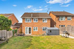 a brick house with a yard with a fence at Badger Haven, Apartment 4 in Brackley