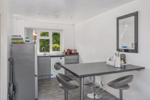 a kitchen with a refrigerator and a table and chairs at Badger Haven, Apartment 4 in Brackley