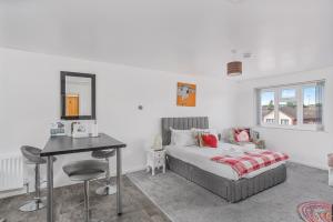 a bedroom with a bed and a desk and a table at Badger Haven, Apartment 4 in Brackley