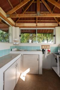 a kitchen with white cabinets and blue tile at Rooster Room in Boksburg +28 photos