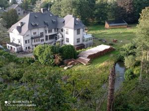 an aerial view of a large white house with a river at Château d'Harnoy in Yvoir