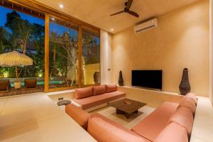 a living room with a couch and a television at La Isla Boutique Residences in Uluwatu