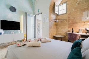 a room with a bed with towels on it at Luxury Rooms in Alezio