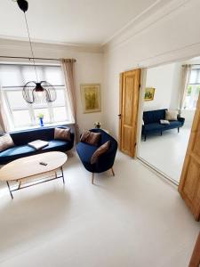 a living room with a blue couch and a table at Exclusive Luxury Apartment with free private parki in Aalborg