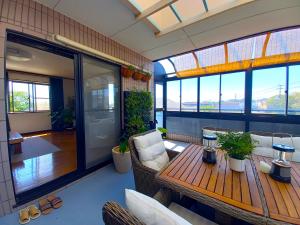 a room with a table and chairs and windows at Villa Nami in Kashima
