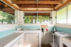 a kitchen with white cabinets and blue tile at Rooster Room in Boksburg