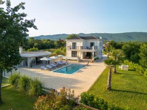 a villa with a swimming pool and a house at Villa Decima near Split - Heated Pool, Tennis Court & Billiards in Dicmo
