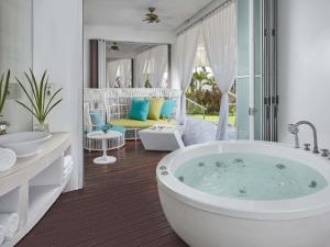 a bathroom with a tub and a living room at Mövenpick Hotel Mactan Island Cebu in Mactan