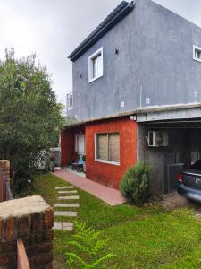 a red and gray house with a driveway at Apartamento El Arrayán in Tacuarembó