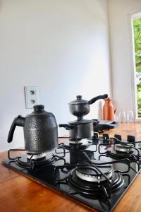 two tea pots sitting on top of a stove at Vila Maré Alta Caraiva in Caraíva