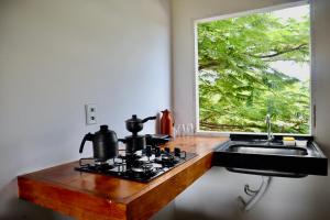 a kitchen with a stove and a sink and a window at Vila Maré Alta Caraiva in Caraíva