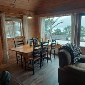 a dining room with a table and chairs and a couch at Cabin in Hjelmeland in Hjelmeland