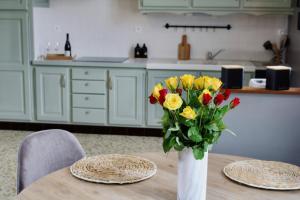 a vase of flowers on a table in a kitchen at Maison de charme in Bourgueil