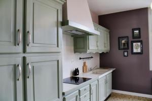 a kitchen with white cabinets and a sink at Maison de charme in Bourgueil +10 photos