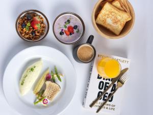a white table with a plate of food and a book at Montraj Coach Sukhumvit Bangkok in Bangkok +39 photos