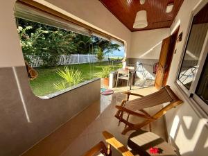 a room with two chairs and a large window at Beach Villa Guesthouse in Grand Anse +16 photos