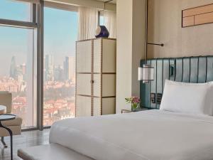 a bedroom with a large bed and a large window at Fairmont Quasar Istanbul Hotel in Istanbul
