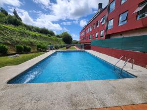 a swimming pool in front of a building at Piso con piscina en Sada in Sada