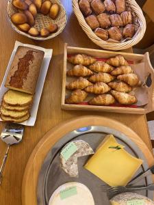 a table topped with different types of bread and pastries at Hôtel du Grand-Mont in Beaufort +49 photos