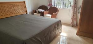 a bedroom with a bed and two chairs and a window at Bethany in Rivière Dragon
