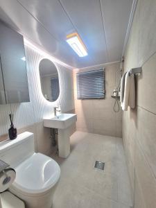 a white bathroom with a toilet and a sink at 원하우스 in Seoul +30 photos