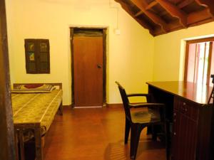 a room with a bed and a desk and a chair at Warriam Road in Chottanikara
