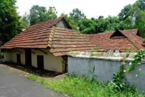 an old house with a roof on the side of a street at Warriam Road in Chottanikara