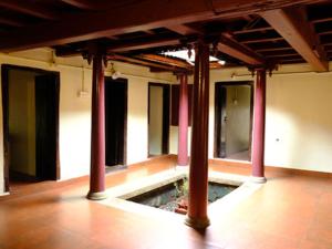 an empty room with pillars in a building at Warriam Road in Chottanikara