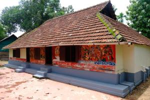 a small house with a tile roof at Warriam Road in Chottanikara