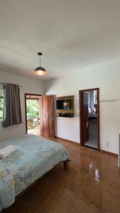 a bedroom with a bed and a television in it at Estadia Cipó Pousada & Piscina in Serra do Cipo
